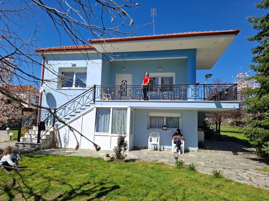 a man standing on the balcony of a house at Dinaki apartment in Florina