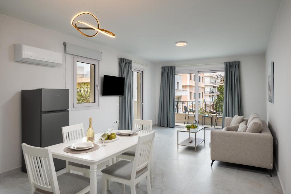 a kitchen and living room with a white table and chairs at Kamara View Apt 1 in Agios Nikolaos