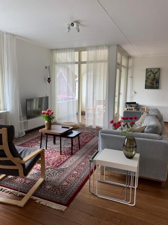 a living room with a couch and a table at Kust Geluk in Schoorl