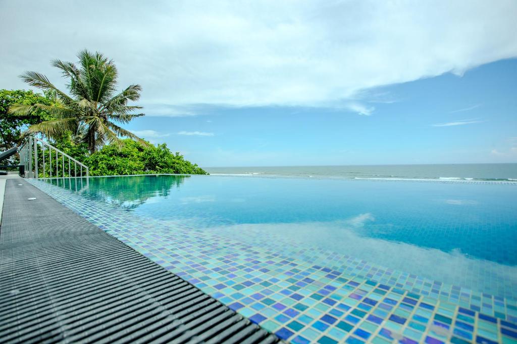 a swimming pool with a view of the ocean at Iconic Polhena in Matara