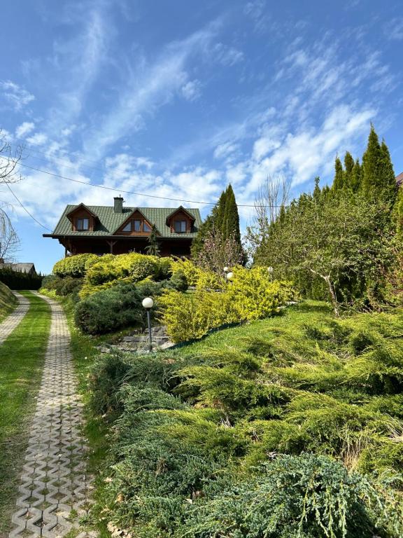 a house on a hill with a cobblestone road at Agroturystyka Ranczo Turzyniec w pobliżu Zwierzyńca in Turzyniec