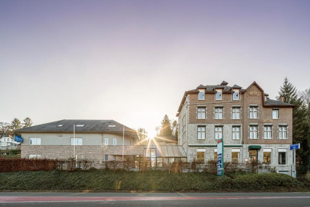 un bâtiment sur le côté d'une rue avec deux maisons dans l'établissement New Hotel de Lives, à Namur