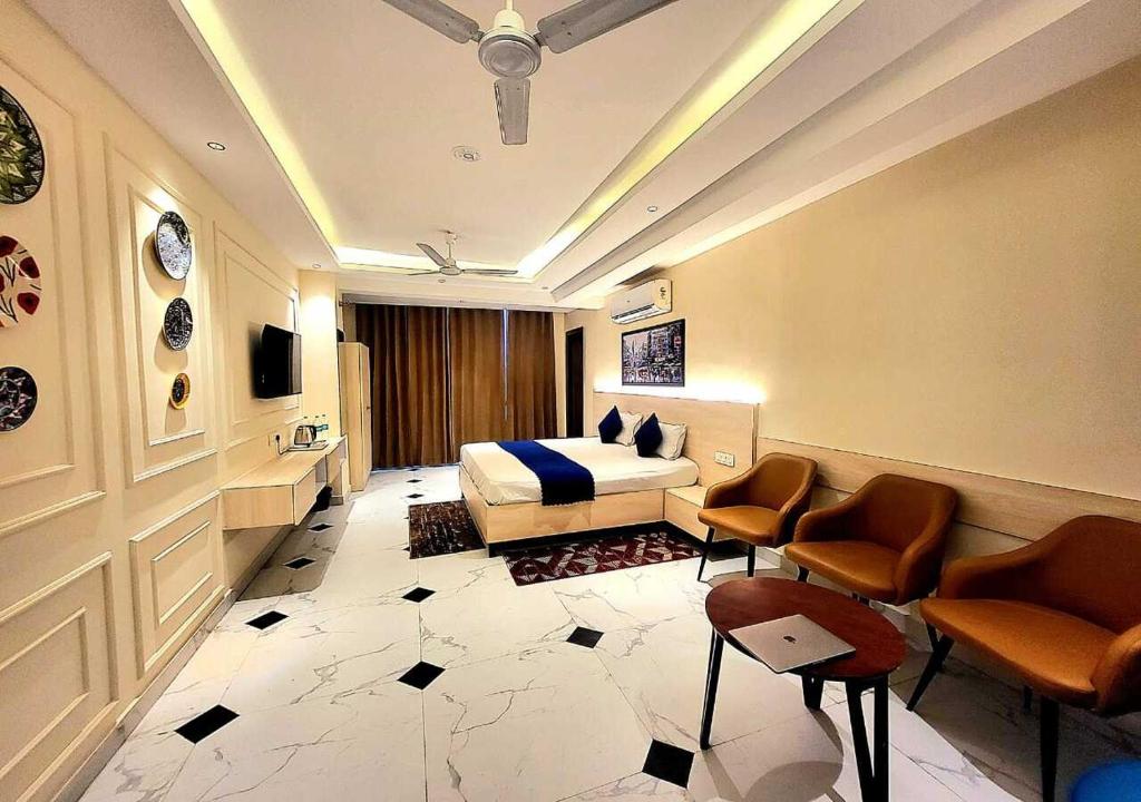 a hotel room with a bed and two chairs at Hotel Ananta Vilas in Khurja