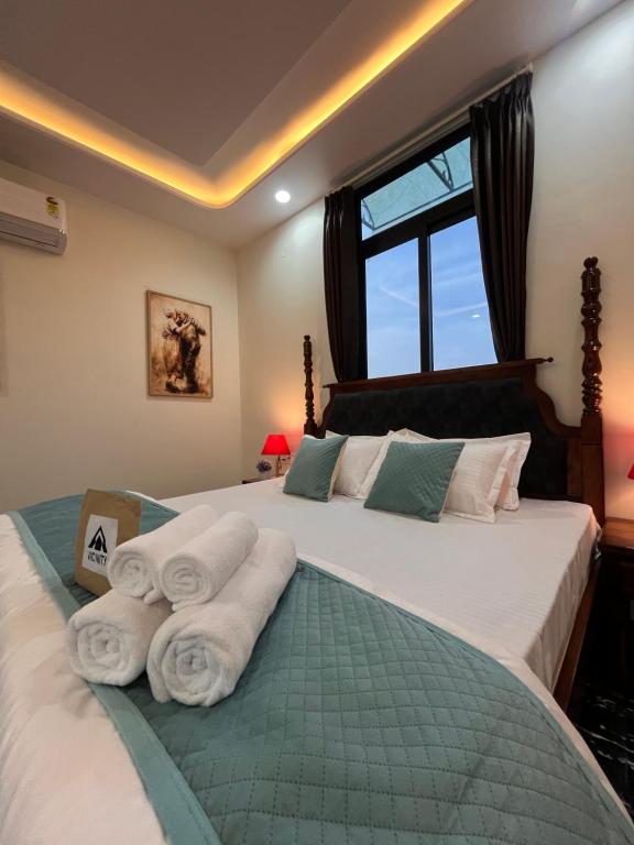 a bedroom with two beds with towels on them at Peace The Green Heaven in Jaipur