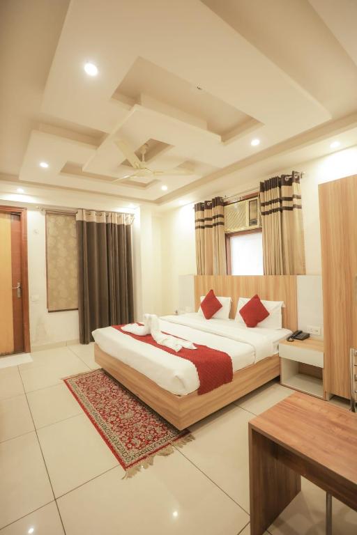 a bedroom with a large bed and a desk in it at Hotel AR Residency in New Delhi