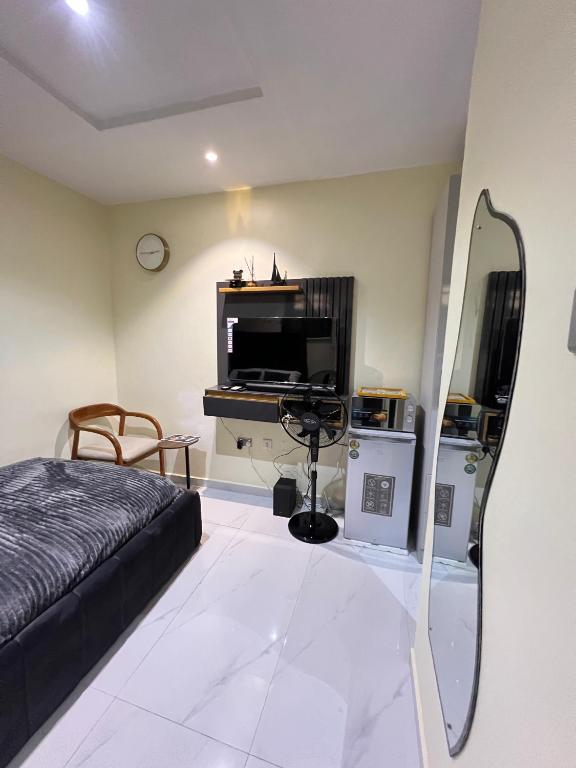 a bedroom with a bed and a tv and a mirror at Studio apartment in Surulere in Lagos
