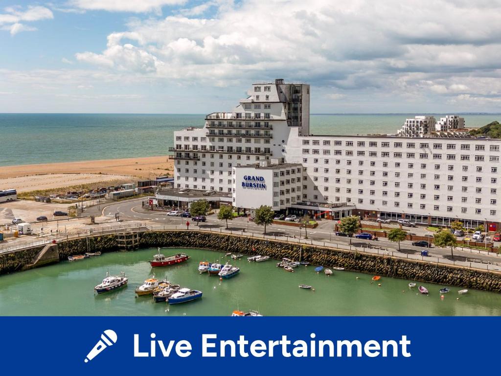 a large white building with boats in a harbor at The Grand Burstin Hotel in Folkestone