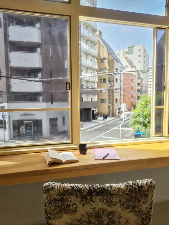 a desk with a window with a book at The hostel kobe in Kobe