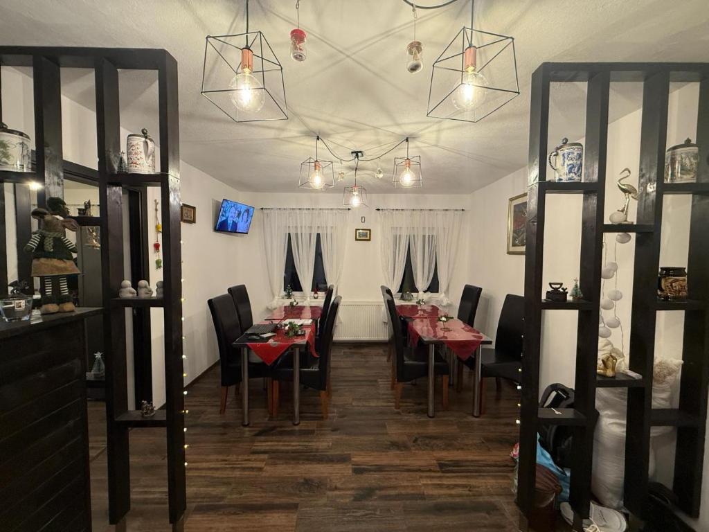 a dining room with tables and chairs and lights at Vila Rhea in Caciulata