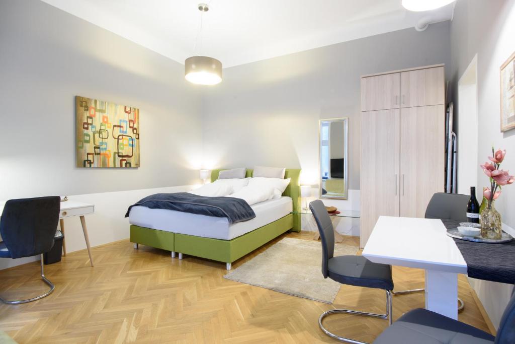 ウィーンにあるVienna Midtown Apartmentのベッドルーム1室(ベッド1台、テーブル、椅子付)
