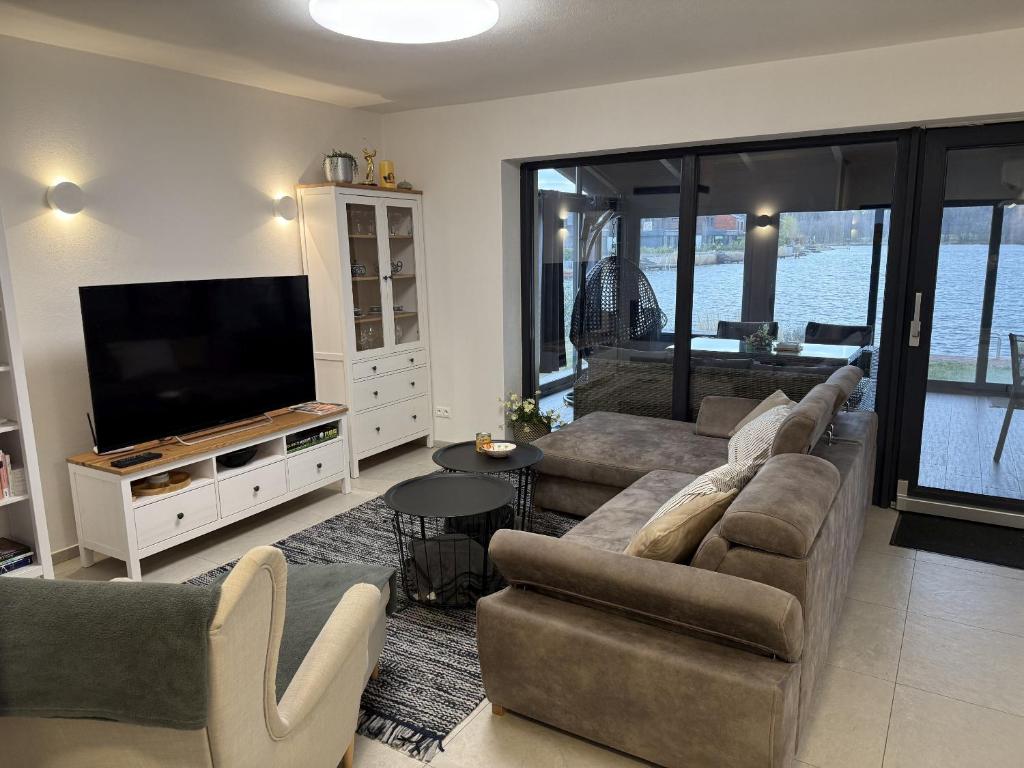 a living room with a couch and a flat screen tv at Vila 512 priamo pri jazere in Šajdíkove Humence