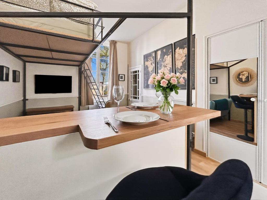 a room with a table with a vase of flowers on it at Superbe Grand Studio dans le vieux Tours avec fraicheur au rendez-vous in Tours