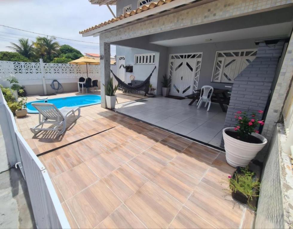 a backyard with a wooden deck and a swimming pool at Casa cinza em frente à praia em condominio in Aracaju