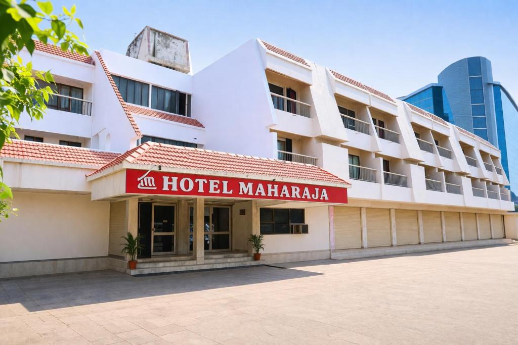 a hotel with a red sign in front of a building at Hotel Maharaja in Rewa