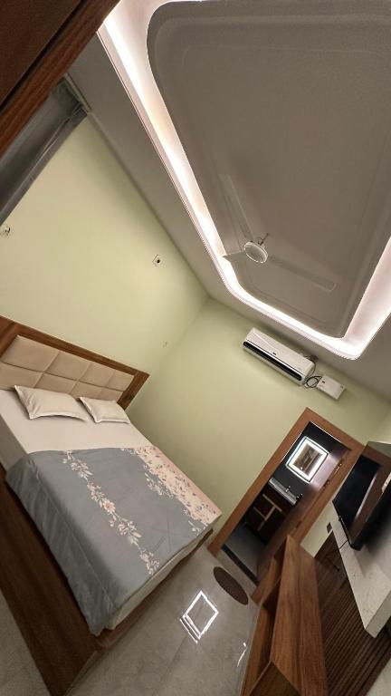 a bedroom with a bed and a room with a ceiling at Mangalam Palace Vrindavan in Chhatikara