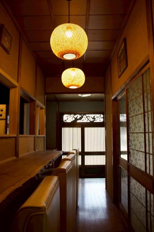 a bar in a restaurant with two lights and benches at ゲストハウス青い輝き in Marugame