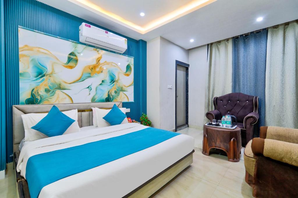 a bedroom with a large bed and a chair at Hotel Brij Stone in Vrindāvan