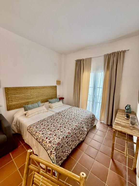 a bedroom with a large bed and a table at Suite Triana in El Rocío