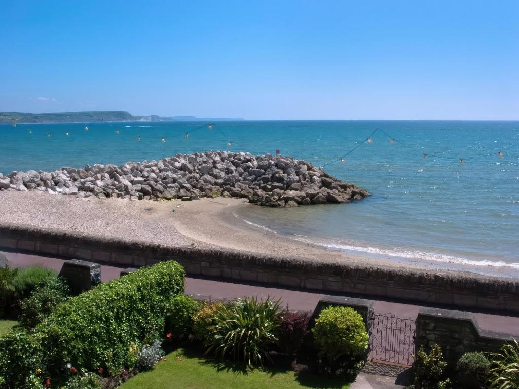 a view of a beach with rocks in the water at Weymouth Bay Apartment C in Weymouth