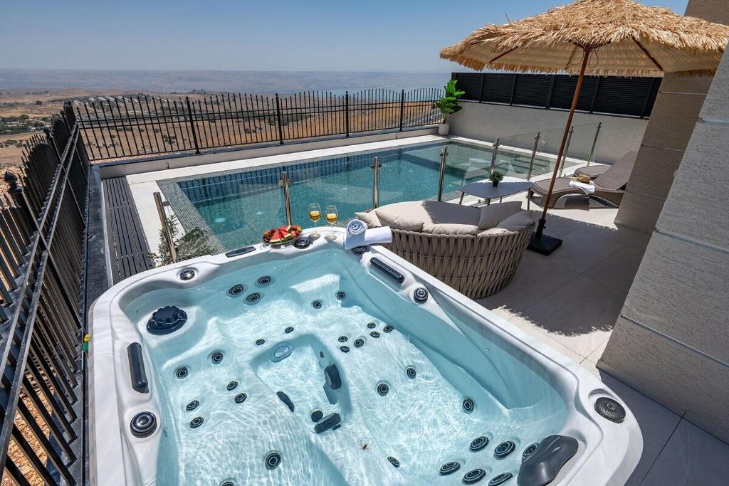 a hot tub on a balcony next to a swimming pool at רויאל בוטיק טווינס 2 in Safed