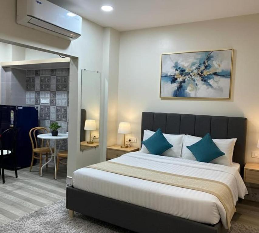 a bedroom with a large bed with blue pillows at Veda Home's B in Agartala