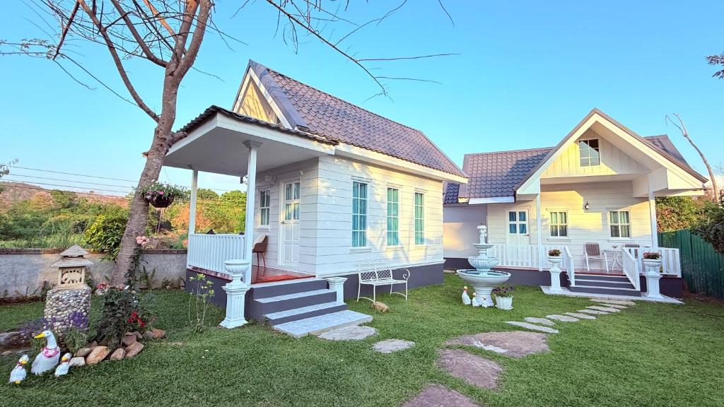 a white house with a porch and a yard at I Hug Homestay ไอฮัก ที่พักเชียงใหม่ in Ban Thap Dua