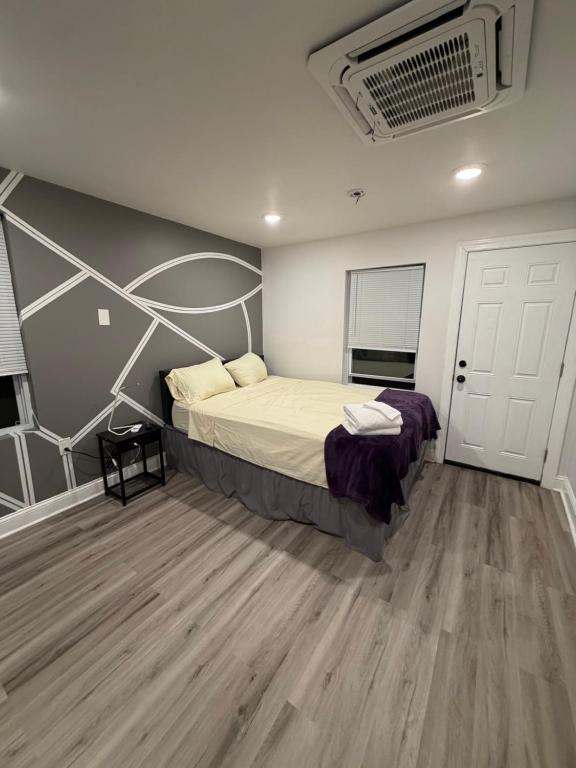 a bedroom with a large bed and a wooden floor at Cozy Modern Studio in Philadelphia