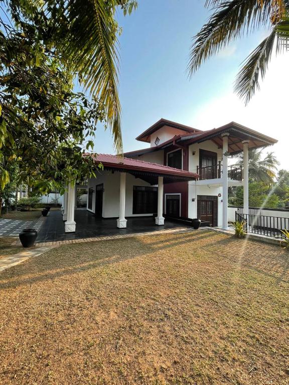 a house with a palm tree in front of it at Mayon's Home in Kalutara