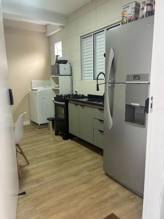 a kitchen with a stainless steel refrigerator and a counter at Kitnet bem equipada para 2 pessoas in Curitiba
