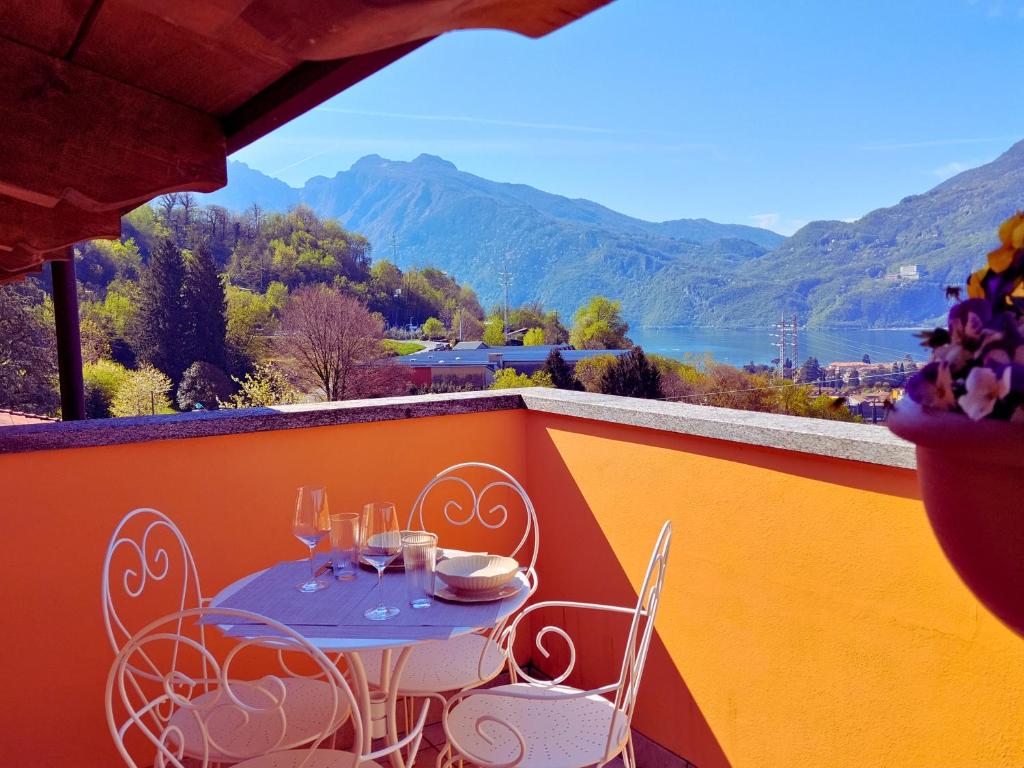 a table and chairs on a balcony with a view at Larius Apartment - Como Lake View - Free Parking in Mandello del Lario