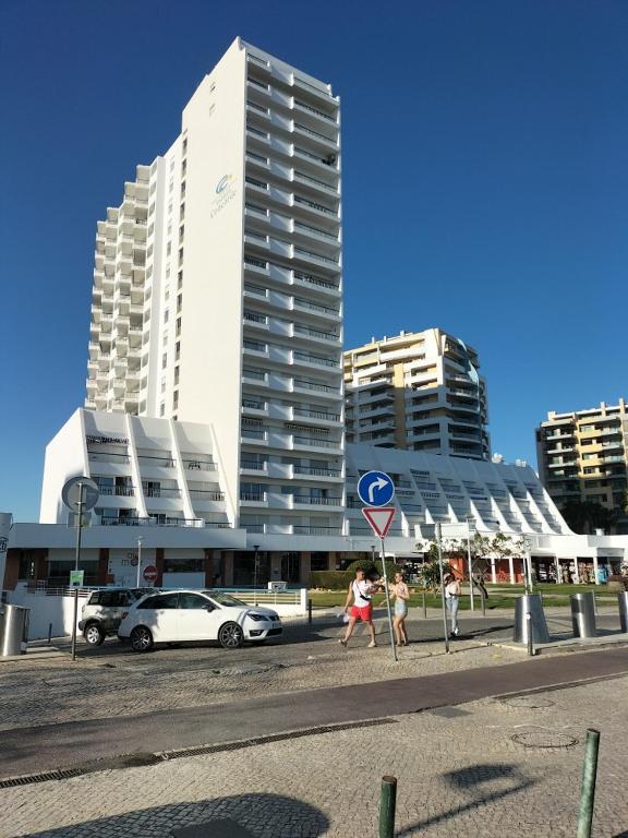 a group of people walking on a street with buildings at Praia Rocha Balcony First Line Beach View Studio in Praia da Rocha