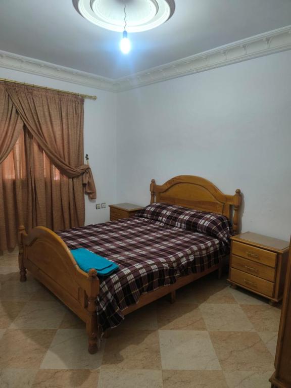 a bedroom with a bed and a dresser and a window at nayla y amira in Martil
