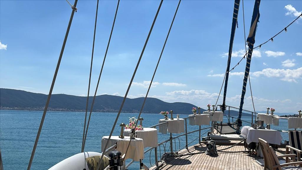 a boat deck with tables and chairs on the water at Meridian bleu in Salamina