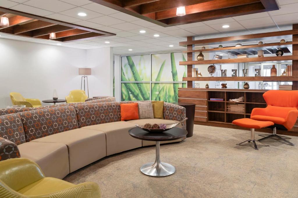 a living room with a couch and a table and chairs at EVEN Hotel Ann Arbor S - University Area by IHG in Ann Arbor