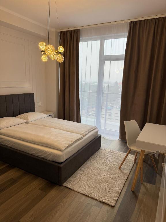 a bedroom with a bed and a large window at Nordic Star in Rădăuţi