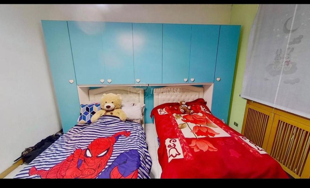 a childs bedroom with a bed with a superhero bedspread at private room in Seveso