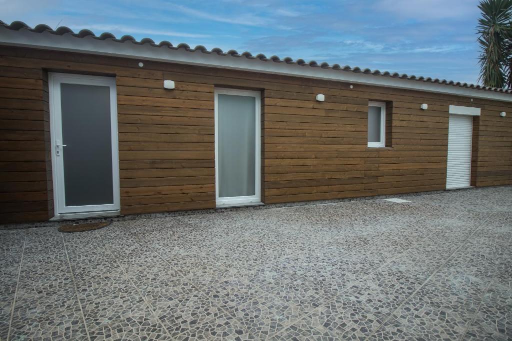 a wooden garage with four doors on it at Entre Raizes in Remédios