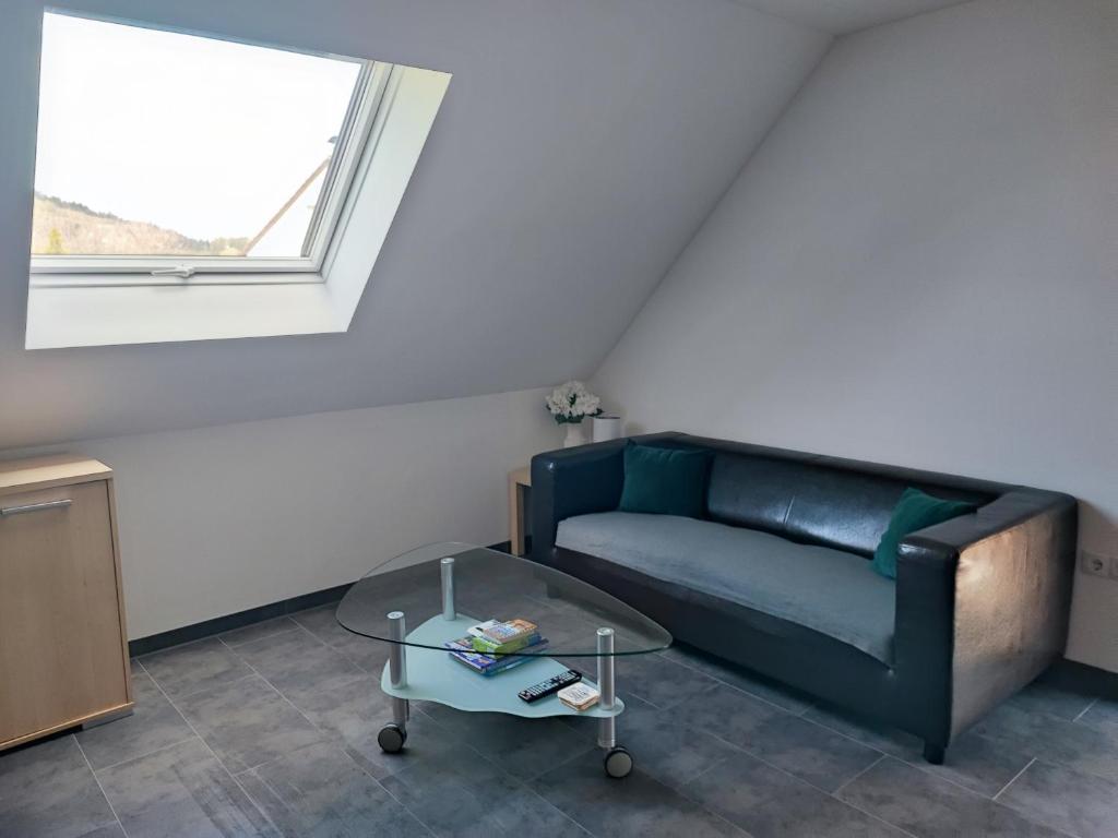 a living room with a couch and a glass table at Ferienwohnung Mühlbach in Igensdorf