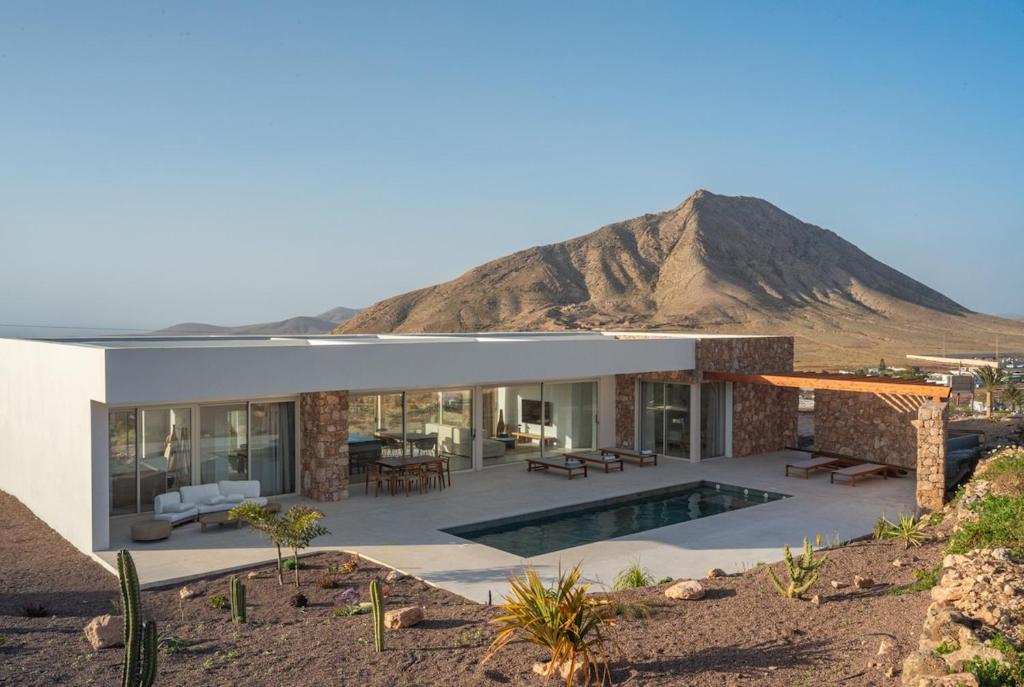 a modern house in the desert with a mountain in the background at Villa James by Aura Collection in Tindaya