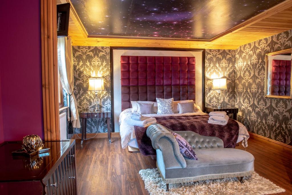 a bedroom with a king sized bed and a couch at Palomino Lodge - Still Rabbit - Hot Tub - Yorkshire in Selby