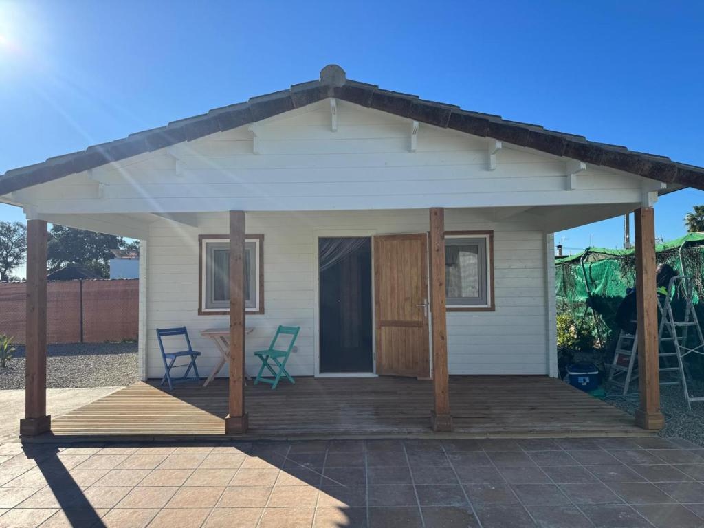 a small white house with a wooden porch at El Palmito Rural Home in Jerez de la Frontera