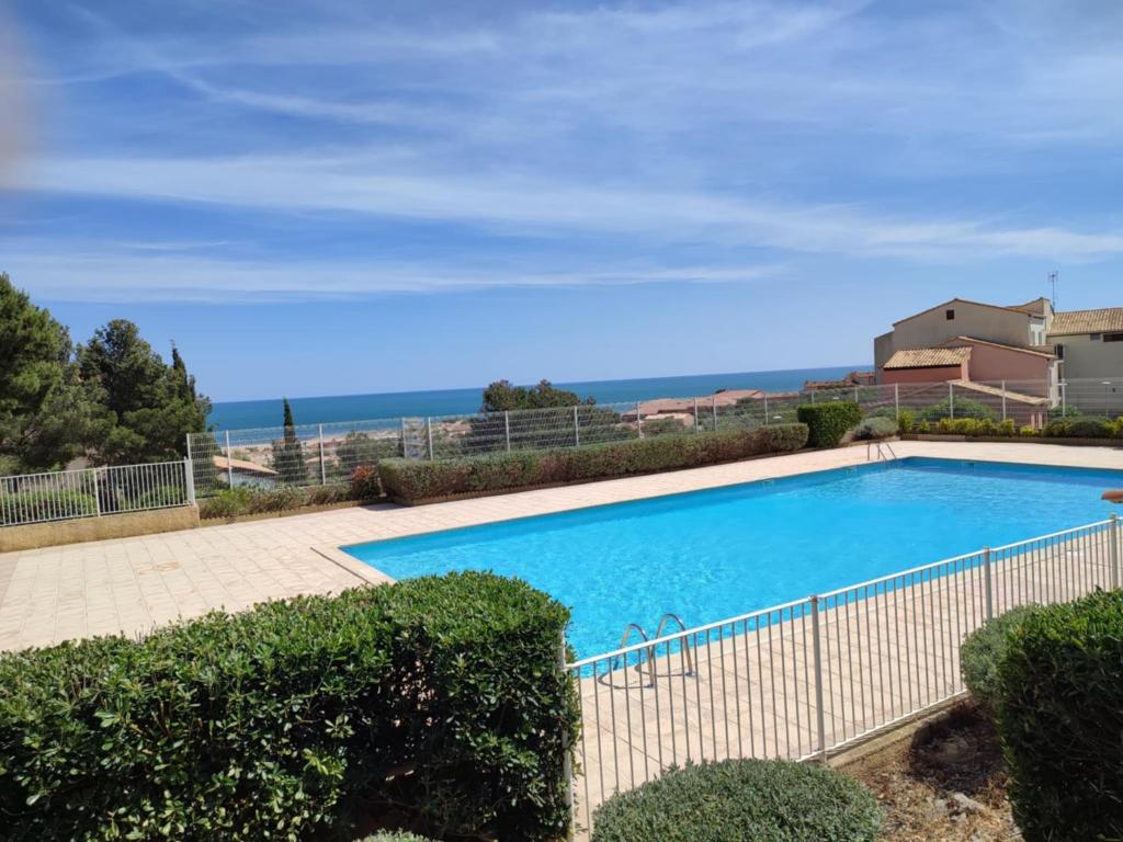 a swimming pool with a view of the ocean at Appt climatisé vues sur mer in Fleury