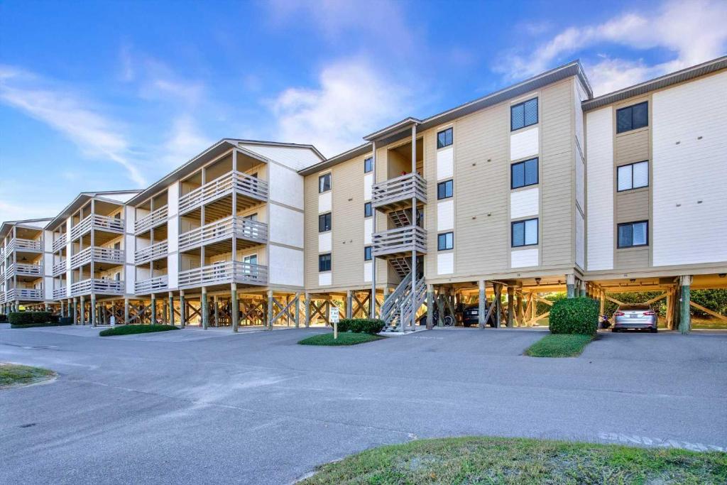 a large apartment building with a parking lot at Lighthouse Point Rental 8B in Tybee Island