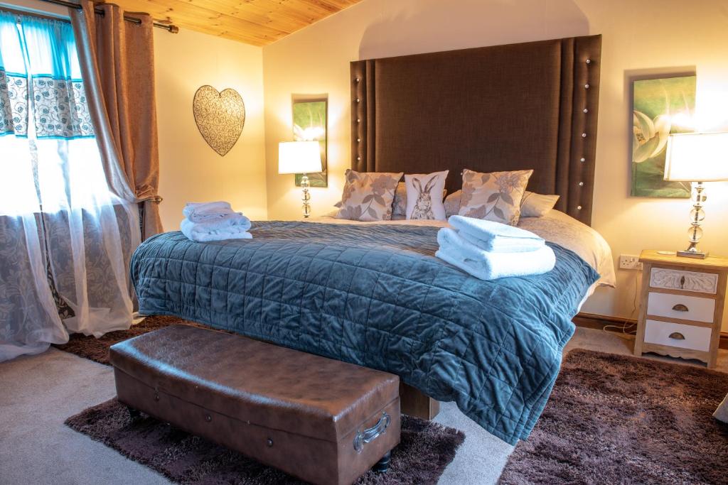 a bedroom with a large bed with towels on it at Britannia Petite Lodge - Still Rabbit - Hot Tub - Yorkshire in Selby