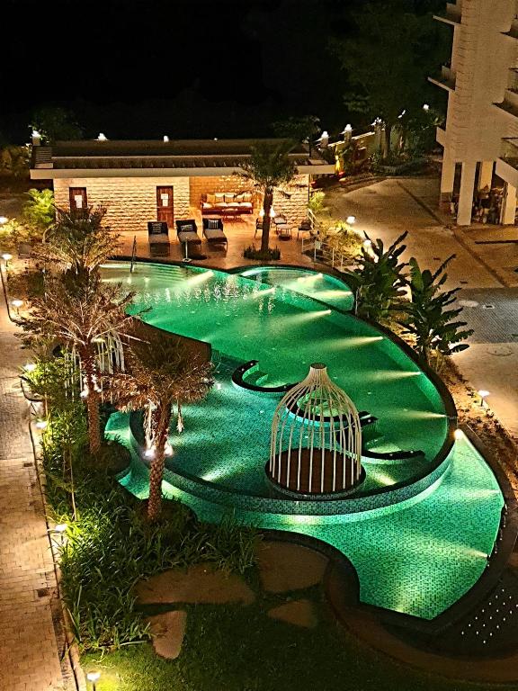 a green swimming pool with a bird cage in it at Panthashala Santiniketan in Srī Niketan