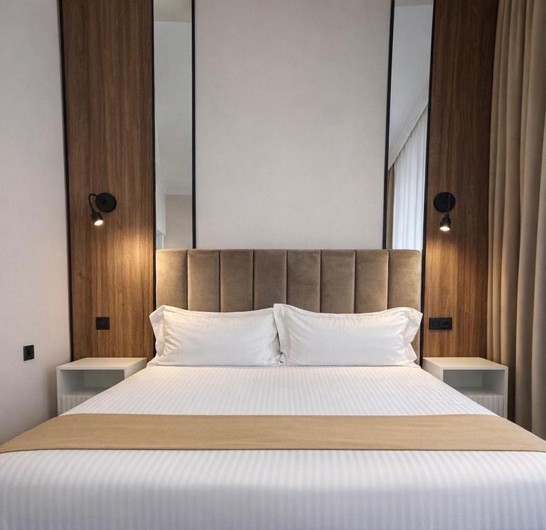 a bedroom with a large bed with white pillows at Pensiunea Brici in Cluj-Napoca