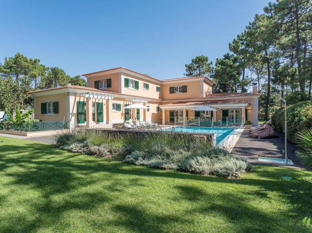 a house with a pool and a yard at Villa Buganvilia III in Aroeira