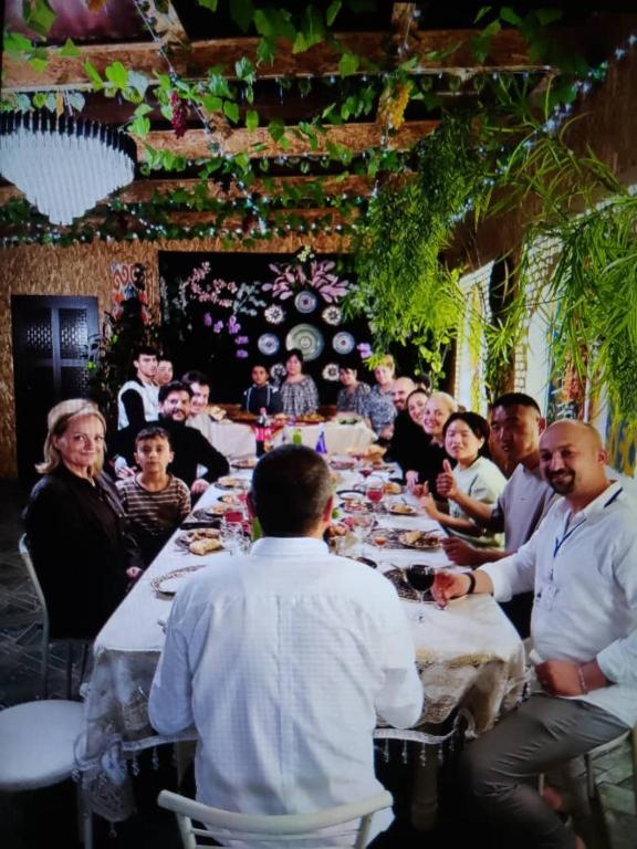 a group of people sitting at a long table at Hotel Ravshanbek in Samarkand