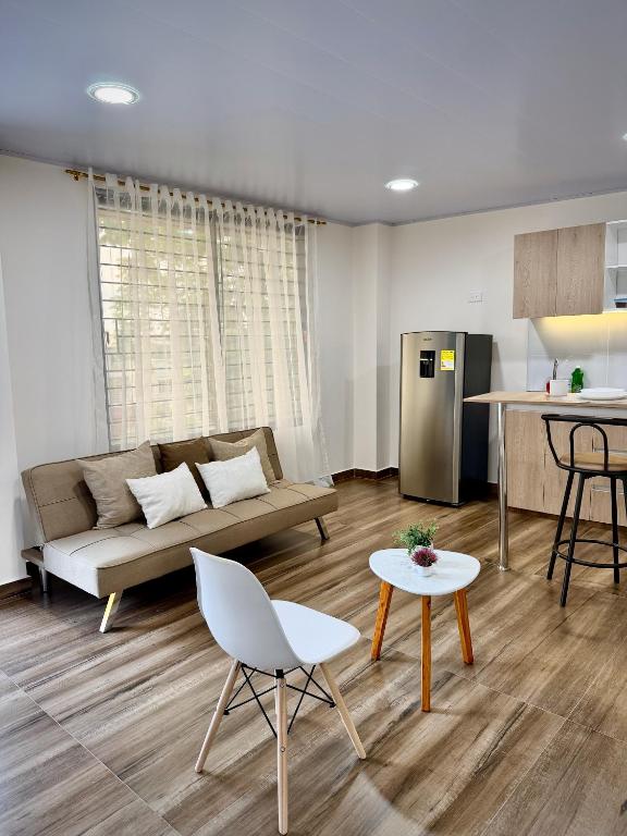 a living room with a couch and a kitchen at Amazonía Luxury in Florencia