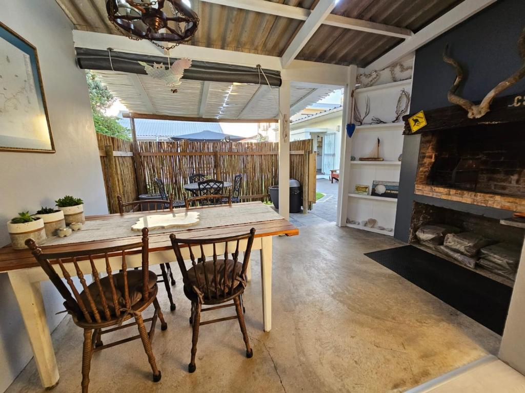a dining room with a wooden table and chairs at Heide Cottage in Struisbaai